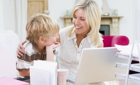 A mother works from home with her son.
